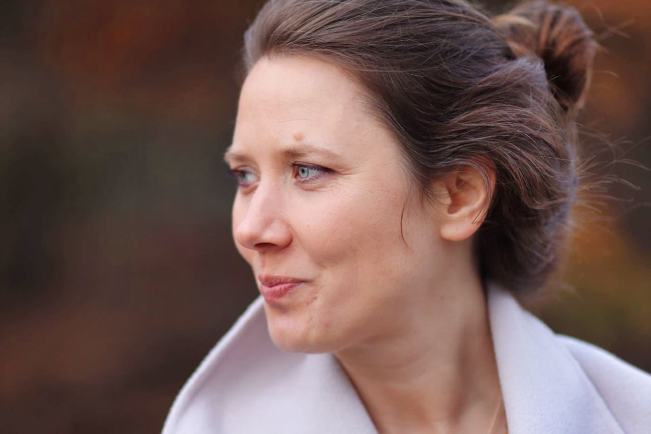 Nohila im Profil mit Haarknoten, sie schaut lächelnd zur Seite